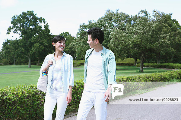 Happy Japanese couple in a park