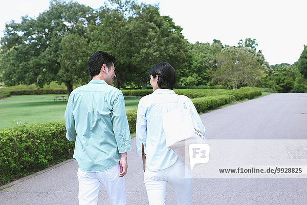 Japanese couple walking in a city park