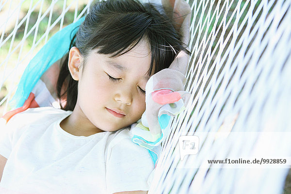 Japanese young girl on hammock in a city park