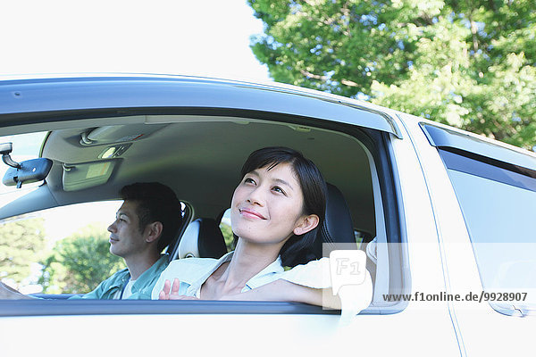 Japanese couple riding a car in nature