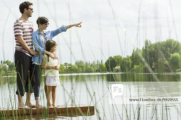 Family standing on dock looking into distance