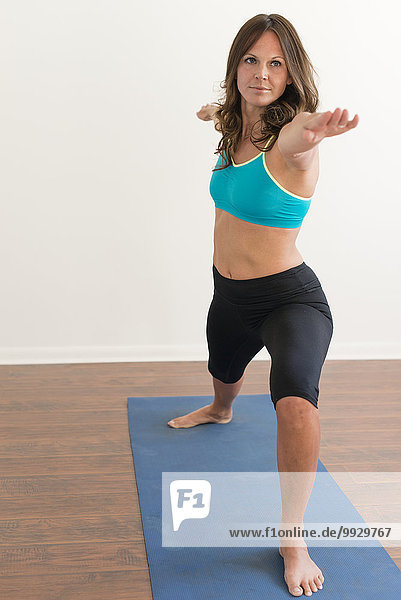 Caucasian woman practicing yoga with arms outstretched