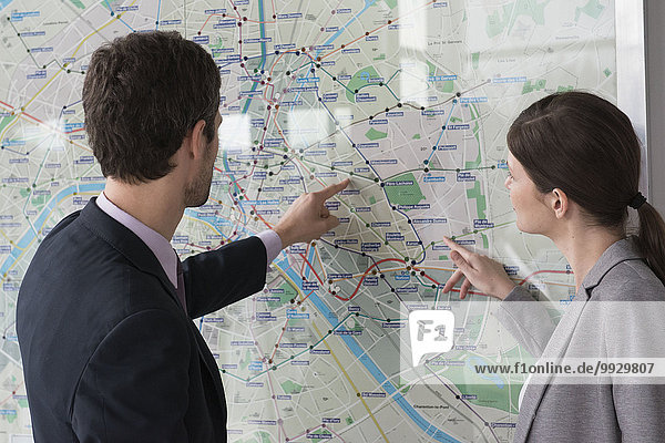 Man and woman looking at Paris metro map together