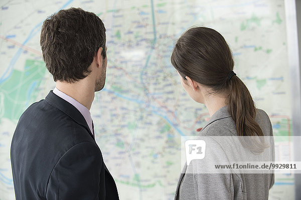 Man and woman looking at Paris metro map together