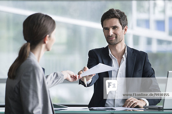 Businessman handing document to client