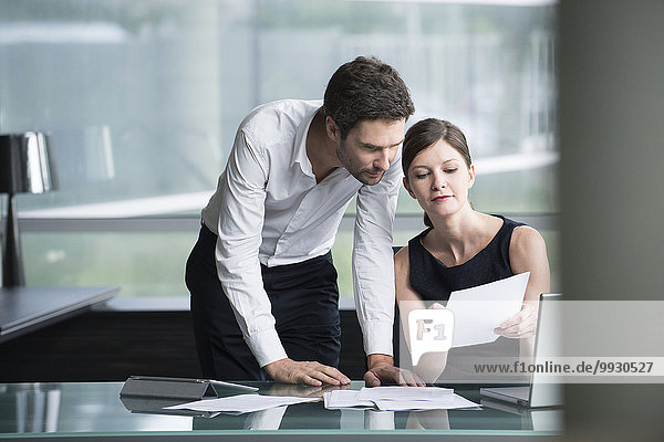 Businesswoman explaining document to associate