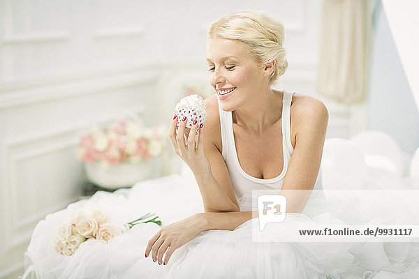 Braut lächeln Bett essen essend isst cupcake