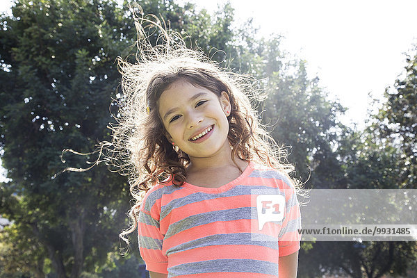 Smiling Hispanic girl standing outdoors