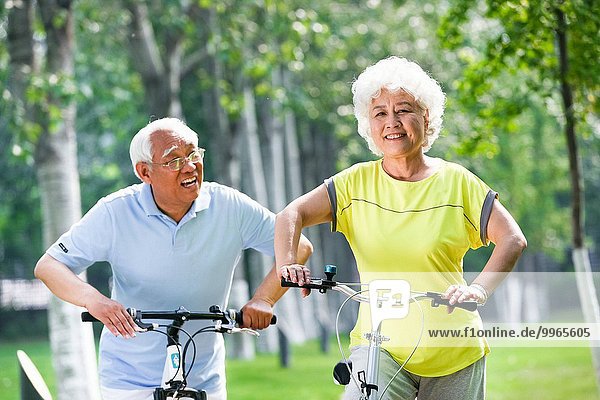 Happy elderly couple riding a bicycle