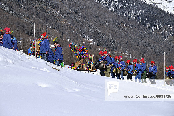 Parade of school boys with big bells  Chalandamarz  Engadine spring tradition  Brail  Lower Engadine  Engadine  Canton of Graubünden  Switzerland  Europe