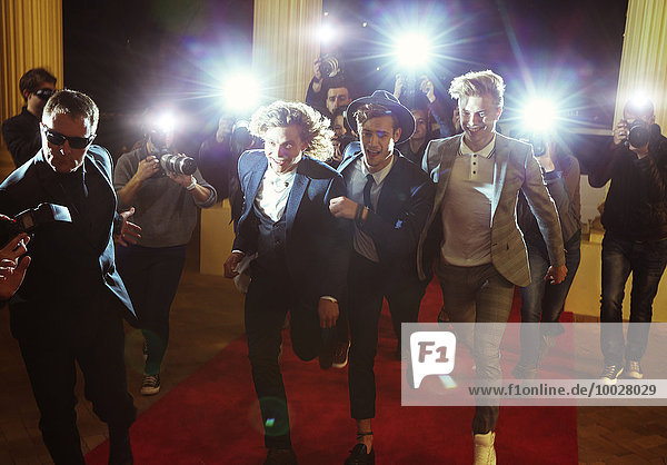 Celebrities running from paparazzi photographers at red carpet event