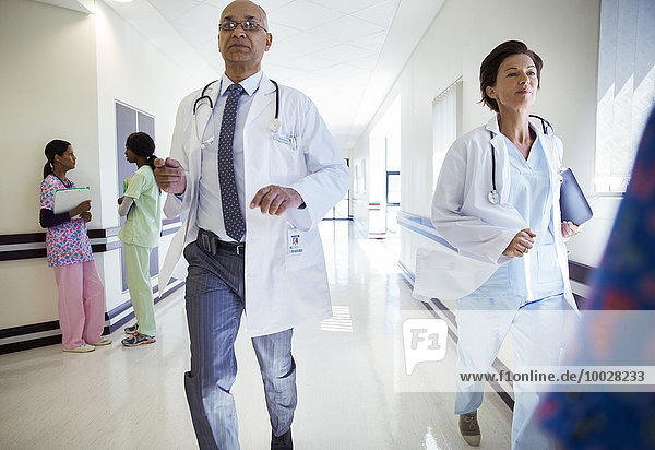 Doctors running down hospital corridor