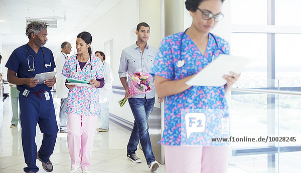 Arzt und Krankenschwester besprechen Krankenakte im Krankenhausflur
