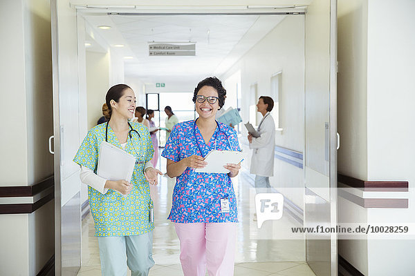 Smiling nurses talking in hospital corridor