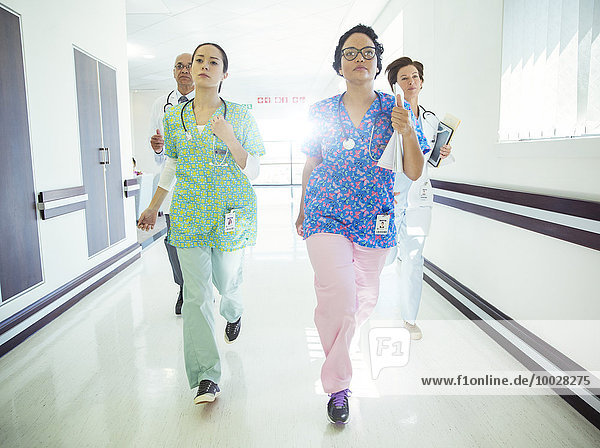 Doctors and nurses running down hospital corridor