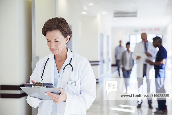 Doctor using digital tablet in hospital corridor