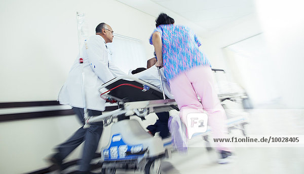 Arzt und Krankenschwester stürmender Patient auf Trage im Krankenhausflur