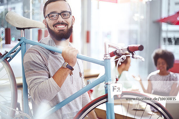 Lächelnder Mann mit Fahrrad im Café
