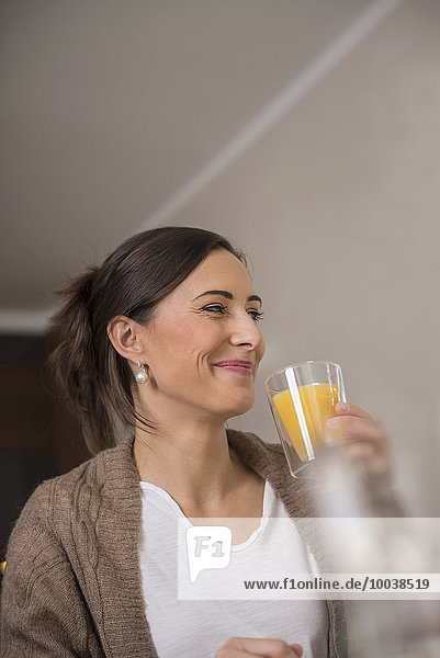 Mid adult woman drinking orange juice  Munich  Bavaria  Germany