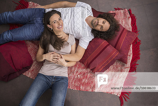 High angle view of mid adult couple lying on floor  Munich  Bavaria  Germany