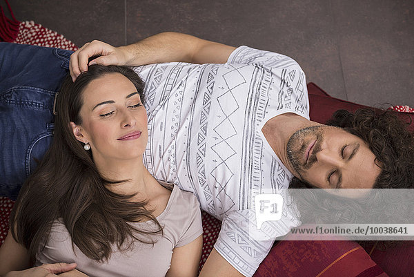 High angle view of mid adult couple sleeping on floor  Munich  Bavaria  Germany
