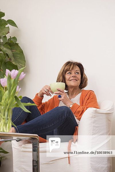 Senior woman dreaming while drinking tea at home  Munich  Bavaria  Germany