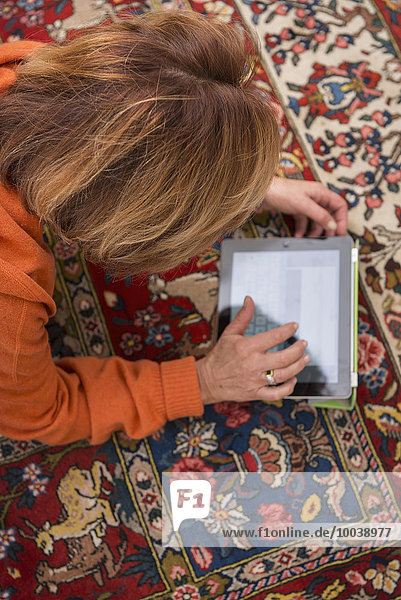 Relaxed senior woman working a digital tablet  Munich  Bavaria  Germany