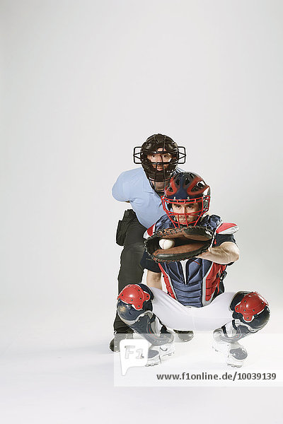 Baseball catcher and chief referee against white background