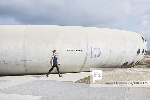 Young woman walking nearby skateboard park  Munich  Bavaria  Germany