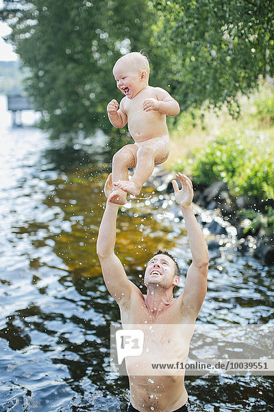 Father throwing baby boy in air