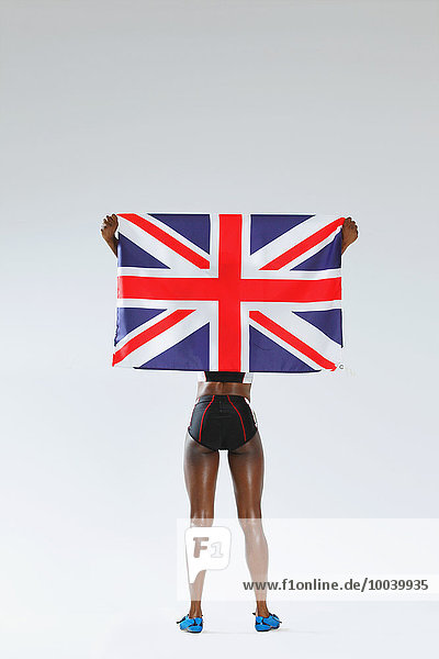 Female Athlete Holding A British Flag  Back View