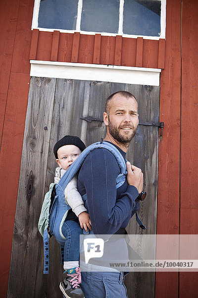 Father carrying his baby son in baby carrier