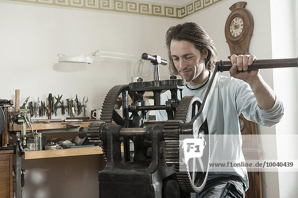Restorer working on a sheet metal rolling mill at workshop  Bavaria  Germany