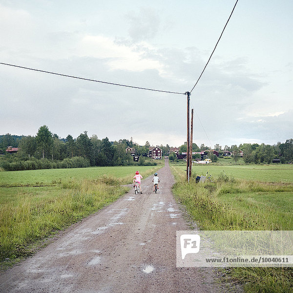 Children cycling on dirt road