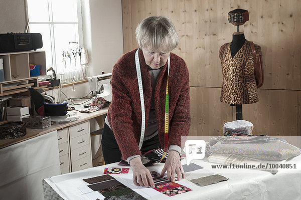 Senior female fashion designer working in workshop Bavaria Germany