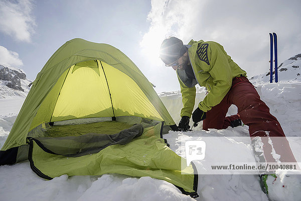 Man constructing tent in snow  Tyrol  Austria