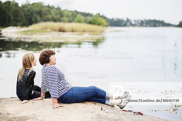 Mother with daughter relaxing at lake