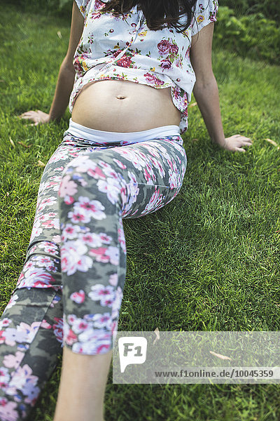 Pregnant woman sitting on a meadow