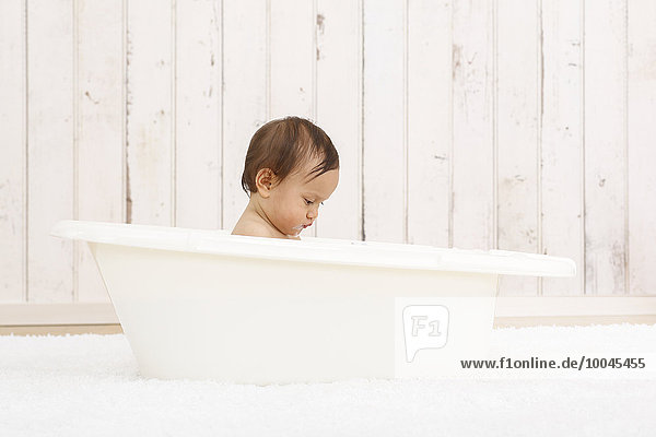 Baby girl bathing in a tub