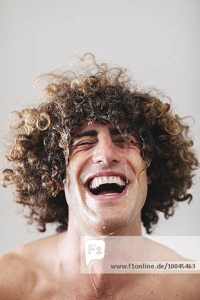 Porträt eines lachenden Mannes mit nassem lockigem Haar