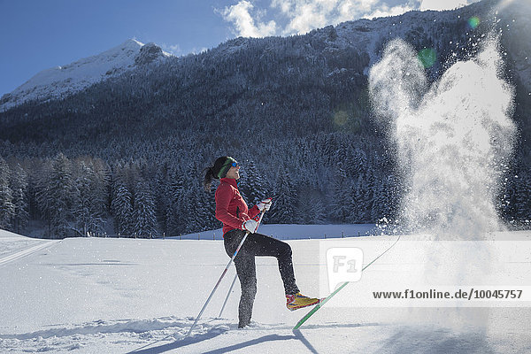 Germany  Bavaria  Inzell  female skier having fun in snow-covered landscape