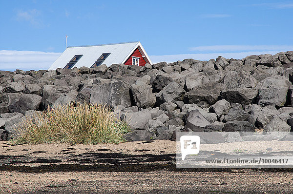 Island  Stokkseyri  Haus versteckt hinter Steinmauer