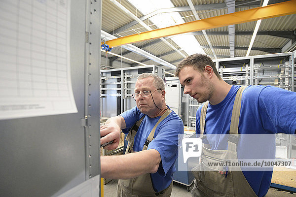 Zwei Arbeiter in einer Schaltschrankfabrik