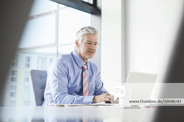 Businessman sitting at desk using laptop