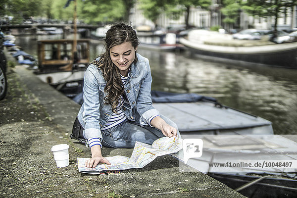 Niederlande,  Amsterdam,  weibliche Touristen erholen sich auf dem Stadtplan