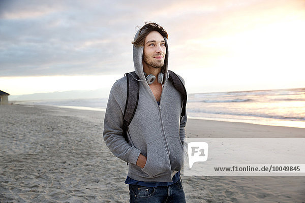 Young man on beach at sunrise
