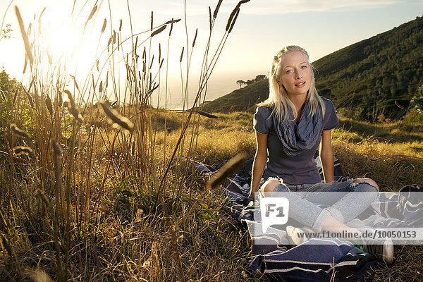 Young woman relaxing on blanket in meadow