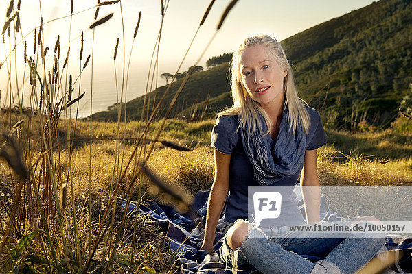 Young woman relaxing on blanket in meadow