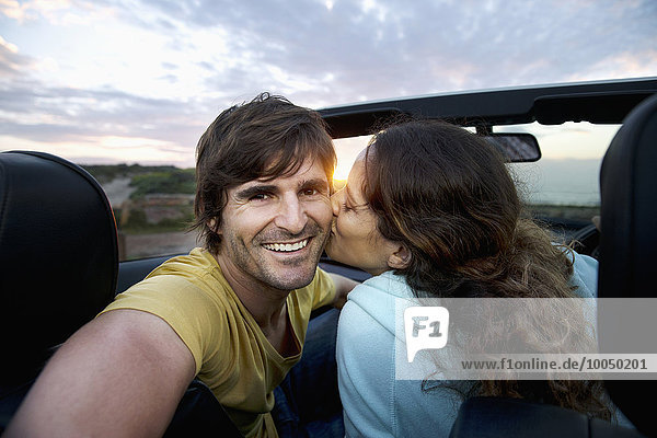 South Africa  happy couple in convertible at the coast at sunrise