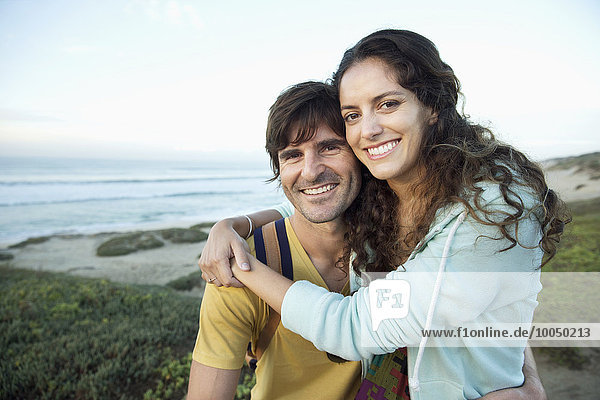 Südafrika  glückliches Paar  das sich an der Küste umarmt